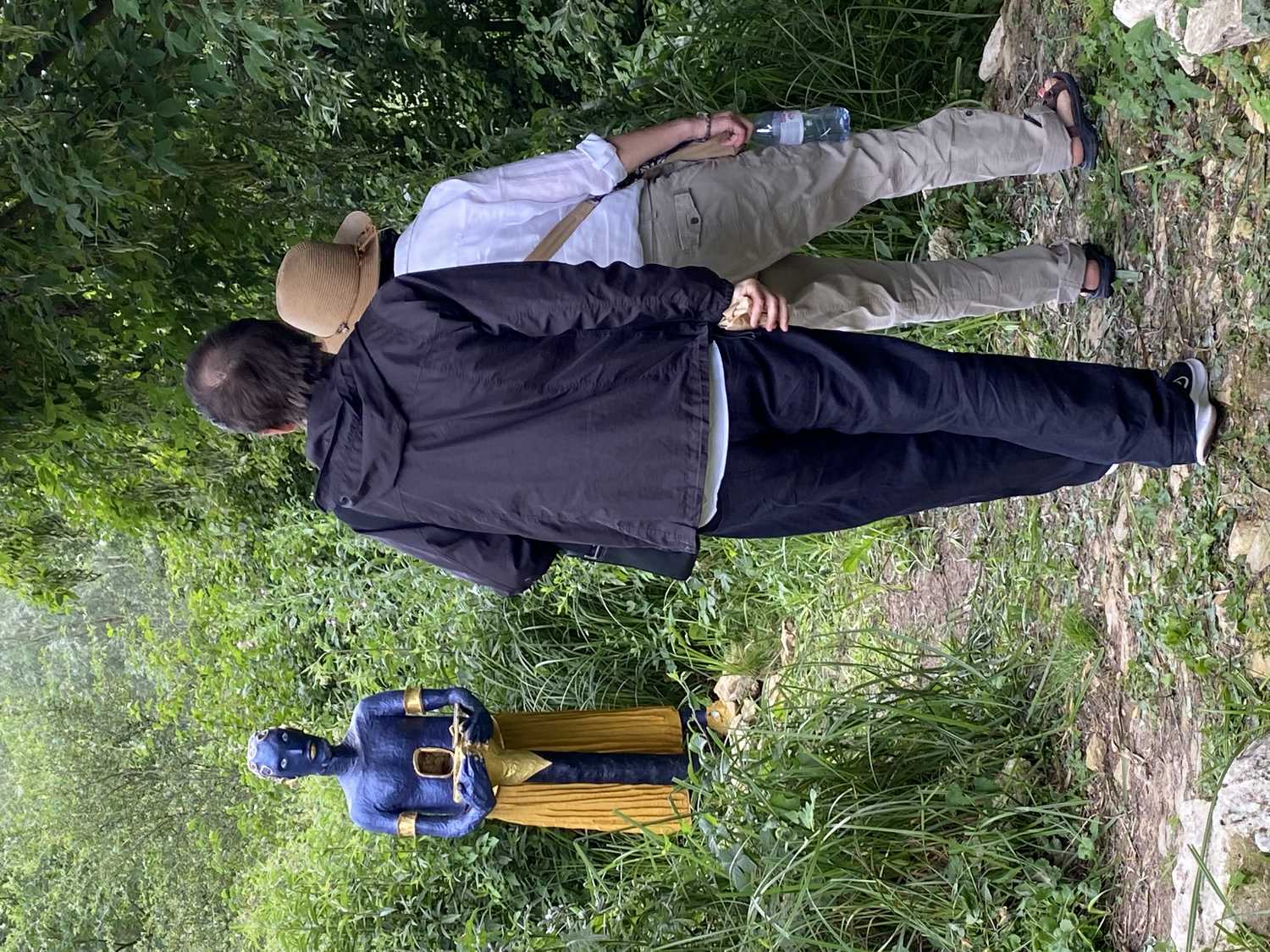 Deux visiteurs devant le gardien des secrets, sculpture interactive en papier mâché de Alex Hays